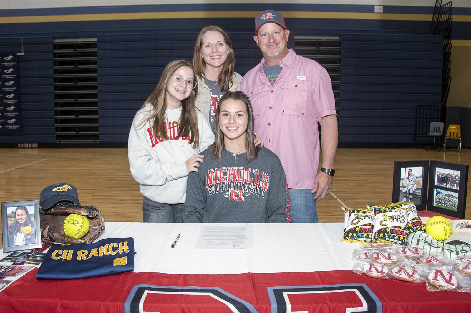 Cypress Ranch senior Molly Yoo, seated, poses with her parents after signing her letter of intent to Nicholls State.